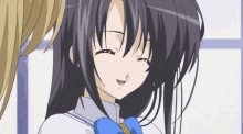 a girl with dark hair and a blue bow on her neck smiles