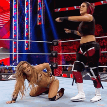two women are wrestling in a ring with the letter w on the ropes