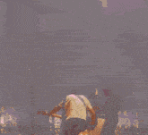 a person is playing a guitar in front of a fire circle