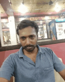 a man in a blue shirt is sitting in a restaurant