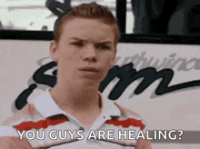 a man is standing in front of a bus and says you guys are healing .