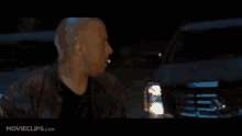 a man holding a gun in a dark room with movieclips.com written on the bottom of the screen