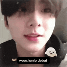 a close up of a person 's face with the words woochanie debut on the bottom right