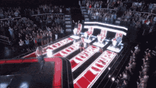 a woman stands on a stage in front of a crowd with a sign that says ' i love you ' on it