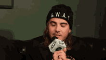 a man wearing a black beanie that says swat
