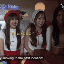 a group of young women are standing in front of a sign that says moving to the next location