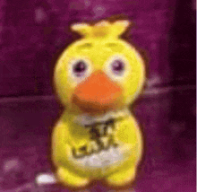 a yellow stuffed duck with a purple background is standing on a table .