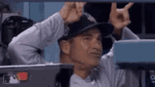 a man wearing a baseball cap is giving the middle finger .