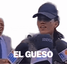 a woman wearing a rode microphone says el queso in spanish