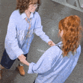 two women shaking hands one wearing a shirt that says pw on it