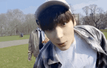 a young man wearing a baseball cap and a plaid shirt with the letters p & b on the sleeve