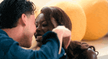 a man is kissing a woman on the forehead in front of yellow balloons