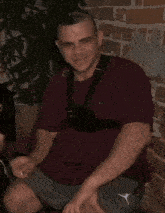a man wearing a maroon shirt and grey shorts with the letter j on the bottom