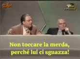 two men sitting at a table with the words non toccare la merda perché lui ci sguazza