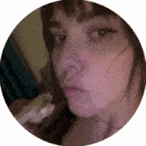 a close up of a woman 's face in a circle with her nose in her mouth .