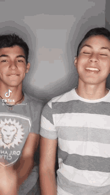 two boys are posing for a picture and one has a shirt that says lion
