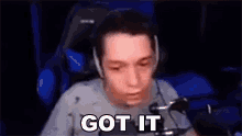 a man wearing headphones and a microphone is sitting in front of a microphone and saying `` got it '' .