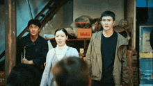 a man in a black shirt stands next to a woman in a grey jacket