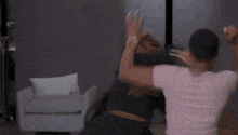 a couple of women are standing next to each other in a living room .