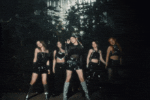a group of young women are posing for a photo in a dark room