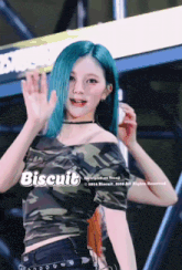a girl with blue hair is wearing a camo top that says biscuit