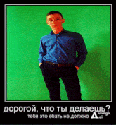 a young man in a blue shirt and black pants stands in front of a green background