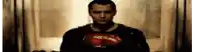 a man in a superman costume is standing in a dark hallway .