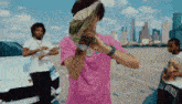 a man in a pink shirt is holding a bunch of money