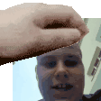 a close up of a person 's hand holding a man 's face .
