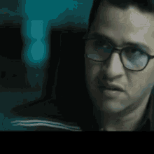 a close up of a man wearing glasses making a face
