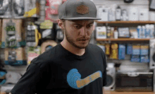 a man wearing a rvca hat and a t-shirt is standing in a store