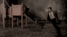 a man with a backpack is running in front of a playground .