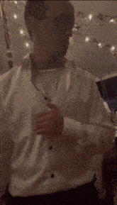 a man in a white shirt and glasses is standing in a room .