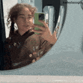 a girl is taking a selfie in front of a mirror with baileybassgifs written on the bottom