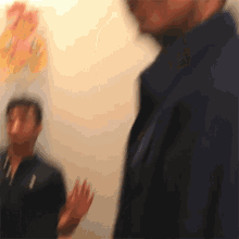 a blurry picture of a man wearing a polo shirt with the letter t on it
