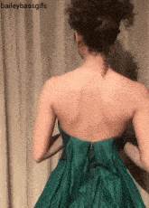 baileybassgifs shows the back of a woman wearing a green strapless dress