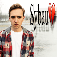 a young man in a plaid shirt is standing in front of a sybau logo