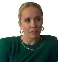a woman wearing gold hoop earrings and a green shirt