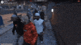 a man wearing a red supreme hoodie is walking down the street