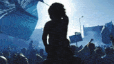 a silhouette of a person standing in front of a crowd with a sign that says ' no parking '