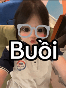 a little girl wearing glasses with the word buoi written on it