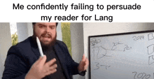 a man with a beard is standing in front of a whiteboard holding a pen .