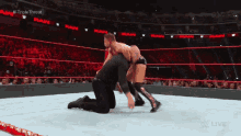 a wrestler is kneeling down in a wrestling ring during a match