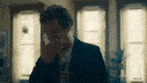 a man covering his mouth with his hand and a netflix logo in the background