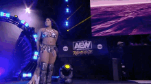 a woman is standing in front of a sign that says aew wrestling rampage .