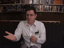 a man in a white shirt has a pen in his pocket that says ' a ' on it