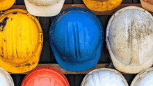a bunch of hard hats are lined up in a row