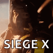a man in a military uniform is sitting in a chair with the word siege x written on the screen .