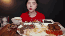 a woman is sitting at a table eating a variety of food