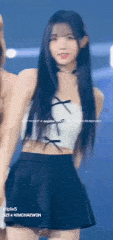 a girl in a white crop top and a black skirt